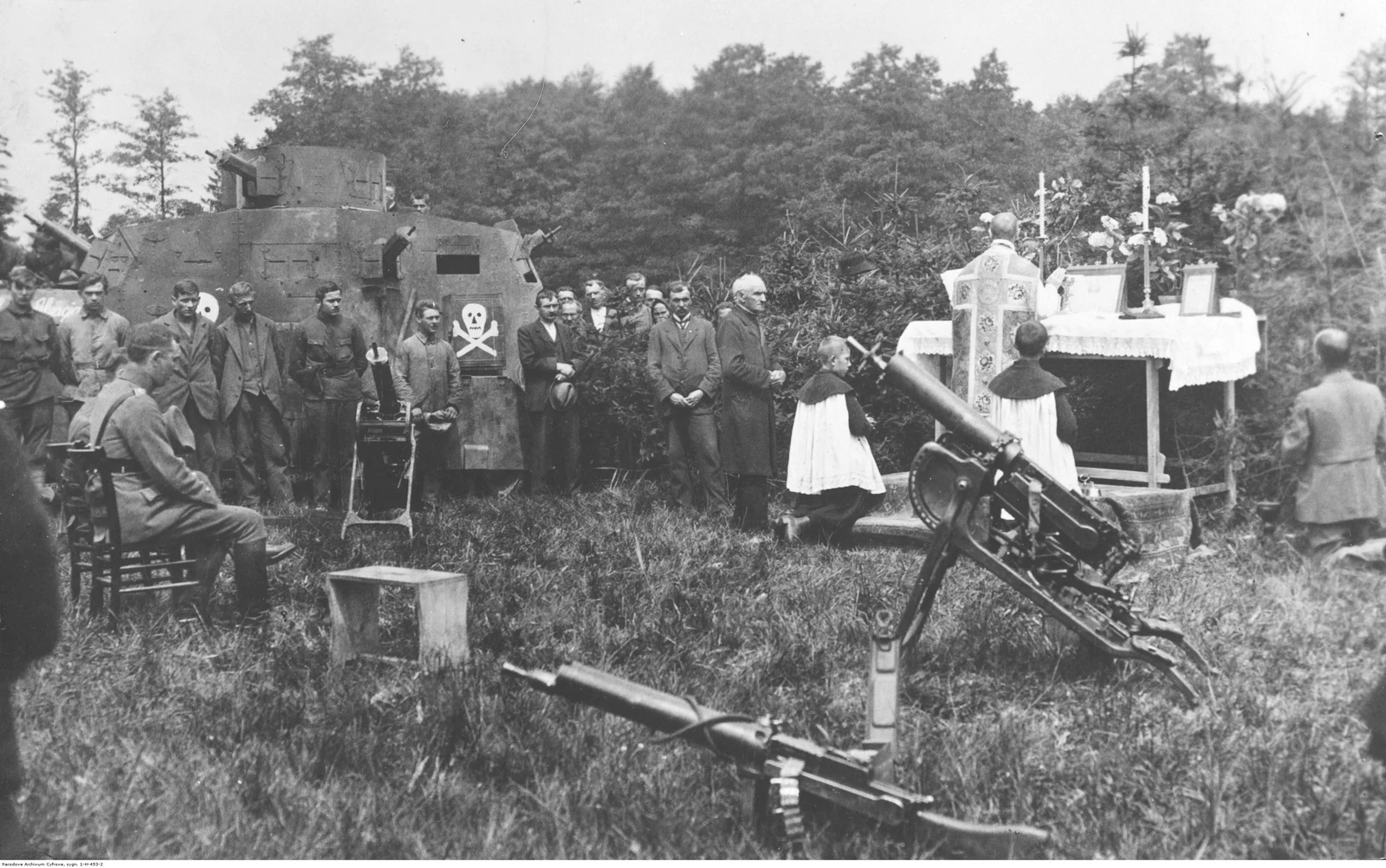 Insurgents attending a field mass, with an armoured car in the background. The consulted description does not establish the exact place or day.